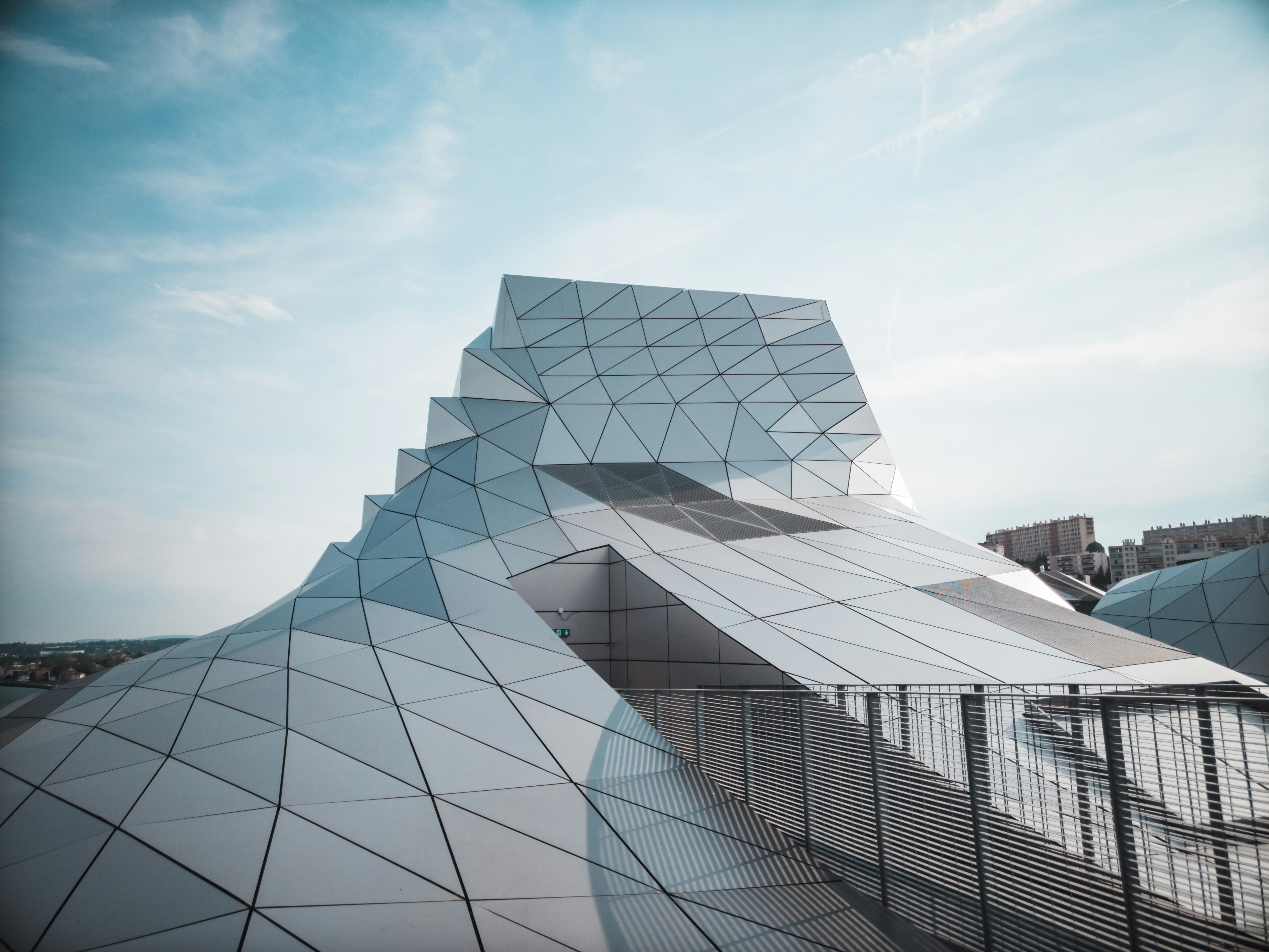 clear glass walled building under blue and white skies